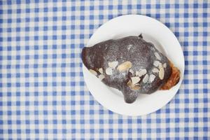 fresh baked chocolate croissant on plate with copy space photo