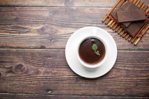 flat composition of dark chocolate cream in a coffee cup on table photo