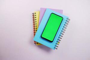 top view of smart phone and notepad on table photo