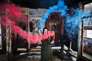 Young girl with blue and red colored smoke bomb in hands. photo
