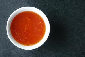 chili tomato sauce in a small jar on table photo