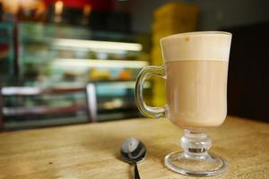 a cup of late coffee and spoon on cafe table photo