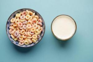 colorful cereal corn flakes in a bowl and milk on color background photo