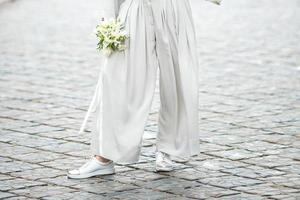 elements of a woman's casual suit with a bouquet of callas photo