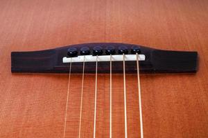 wood texture of lower deck of six strings acoustic guitar on white background. guitar shape photo