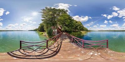 full seamless spherical hdri panorama 360 degrees  angle view on wooden pier of huge lake or river in sunny summer day and windy weather with beautiful clouds in equirectangular projection, VR content photo