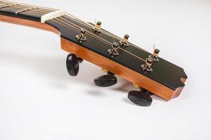 Clavijas de afinación en la cabeza de la máquina de madera de guitarra de seis cuerdas sobre fondo blanco. foto