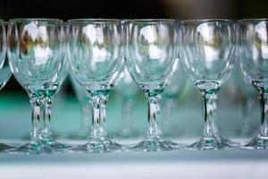 lot of empty glasses on the reception party table. Close up at row of glasses prepare to service for dinner party photo