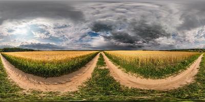 vista de ángulo de 360 grados de panorama hdri esférico completo sin costuras en camino de grava entre campos con nubes impresionantes antes de la tormenta en proyección equirectangular con cenit y nadir, para contenido vr ar foto