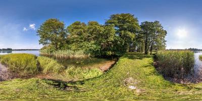 vista de ángulo de 360 grados de panorama hdri esférico sin costuras en la costa de hierba de un río o lago enorme en un día soleado de verano y clima ventoso en proyección equirectangular con cenit y nadir, contenido vr ar foto