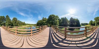 full seamless spherical hdri panorama 360 degrees  angle view on wooden pedestrian bridge over the river canal in equirectangular projection with zenith and nadir, VR AR content. photo