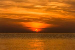 cielo de puesta de sol con espectaculares nubes de puesta de sol sobre el mar. hermoso amanecer sobre el océano foto