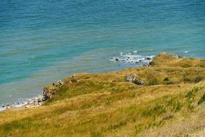 Seascape overlooking hills with dry grass photo