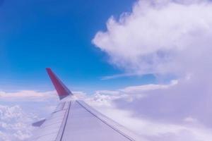 Wing of an airplane above white clouds. photo