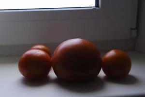 red ripe eco-friendly tomatoes on the windowsill on a sunny morning photo