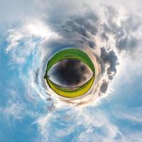 pequeño planeta transformación de panorama esférico 360 grados. vista aérea abstracta esférica en el campo en una agradable velada con impresionantes nubes hermosas. curvatura del espacio. foto