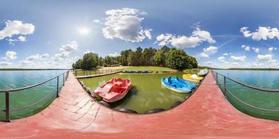 full seamless spherical hdri panorama 360 degrees angle view on wooden pier of huge lake or river with colored old vintage plastic catamarans and boats in equirectangular projection, VR content photo