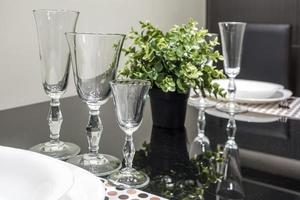 banquet table served with instruments and decorated with empty wine glasses photo