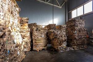 Paper pressed bales at the modern waste hazardous processing plant. Separate garbage collection. Recycling and storage of waste for further disposal. Business for sorting and processing of waste. photo