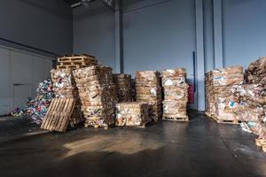 Paper pressed bales at the modern waste hazardous processing plant. Separate garbage collection. Recycling and storage of waste for further disposal. Business for sorting and processing of waste. photo