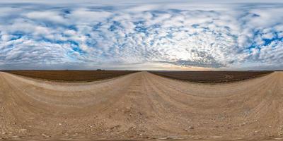 panorama hdri esférico completo sin costuras vista en ángulo de 360 grados en camino de grava entre campos en el día de otoño con hermosas nubes en proyección equirectangular, listo para contenido de realidad virtual vr ar foto