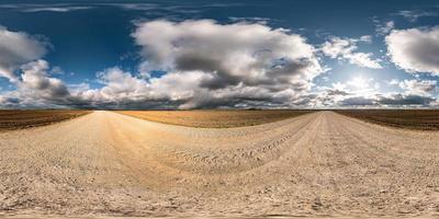 full seamless spherical hdri panorama 360 degrees angle view on gravel road among fields in autumn day with beautiful clouds in equirectangular projection, ready for VR AR virtual reality content photo