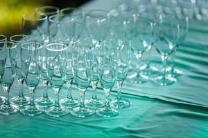 lot of empty glasses on the reception party table. Close up at row of glasses prepare to service for dinner party photo