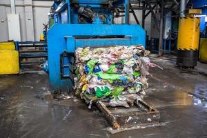 Equipment for pressing debris sorting material to be processed in modern waste recycling plant. garbage press on modern waste recycling processing plant. Business for sorting and processing of waste. photo