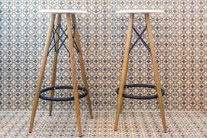 two bar stools stand against a wall in a cafe photo