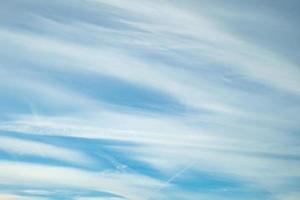 fondo de cielo azul con diminutas nubes stratus cirrus rayadas. día despejado y buen tiempo ventoso foto