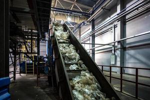 moving conveyor transporter on Modern waste recycling processing plant. Separate and sorting garbage collection. Recycling and storage of waste for further disposal. photo