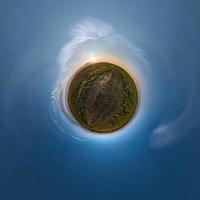 Little planet transformation of spherical panorama 360 degrees. Spherical abstract aerial view in field with awesome beautiful clouds. Curvature of space. photo