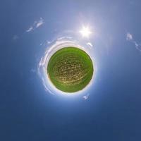 Little planet transformation of spherical panorama 360 degrees. Spherical abstract aerial view in field with awesome beautiful clouds. Curvature of space. photo