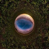 pequeño planeta transformación de panorama esférico 360 grados. vista aérea abstracta esférica en el campo en una agradable velada con impresionantes nubes hermosas. curvatura del espacio. foto