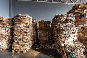 Paper pressed bales at the modern waste hazardous processing plant. Separate garbage collection. Recycling and storage of waste for further disposal. Business for sorting and processing of waste. photo