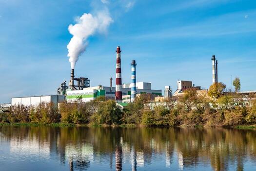 pipes of woodworking enterprise plant sawmill near river. Air pollution concept. Industrial landscape environmental pollution waste of thermal power plant photo