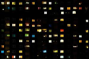 Flat night panorama of multicolor light in windows of multistory buildings. life in big city photo