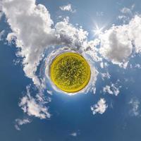 Little planet transformation of spherical panorama 360 degrees. Spherical abstract aerial view in field with awesome beautiful clouds. Curvature of space. photo