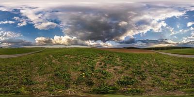 panorama hdri esférico completo sin costuras vista en ángulo de 360 grados entre campos en la tarde de primavera con nubes asombrosas antes de la tormenta en proyección equirectangular, listo para contenido de realidad virtual vr ar foto