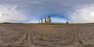 panorama hdri esférico completo sin costuras vista en ángulo de 360 grados cerca de silos de plata para secado, limpieza y almacenamiento de productos agrícolas en proyección equirectangular, listo para vr ar realidad virtual foto