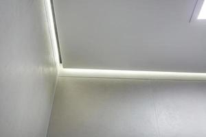 halogen spots lamps on suspended ceiling and drywall construction in in empty room in apartment or house. Stretch ceiling white and complex shape. photo