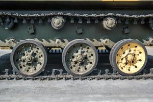 tracks and wheels of tank, armored vehicles on the street in green khaki color photo