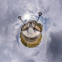 Little planet transformation of spherical panorama 360 degrees. Spherical abstract aerial view in field with awesome beautiful clouds. Curvature of space. photo