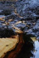 crude oil spill on the stone at the beach photo