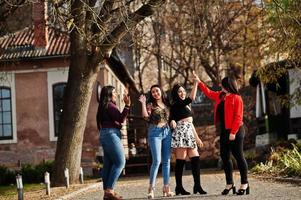 Group of four happy and pretty latino girls from Ecuador posed at street. photo