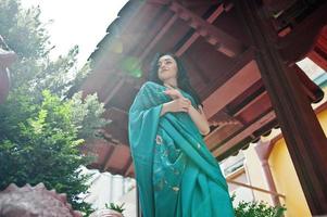 retrato de una hermosa brumette india o modelo de mujer hindú contra una casa tradicional japonesa. foto