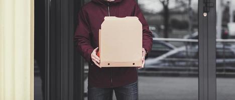 Delivery man employee hold empty cardboard box photo