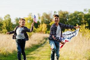 Two brothers running with USA flag. America holiday. Proud to be children of country. photo