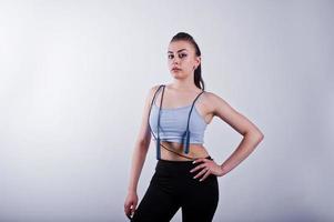 Cheerful attractive young fitness woman in top and black leggings with jump rope isolated over white background. photo