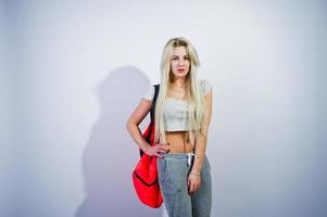 Blonde sporty girl with big sport bag posed at studio against white background. photo